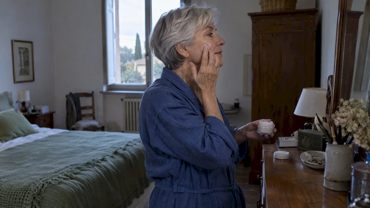 Donna adulta che applica una crema come parte della sua routine notturna
